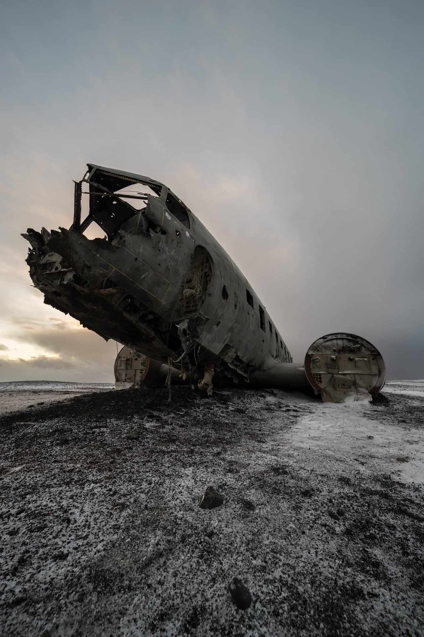 Flugzeugwrack in schwarzer Lavalandschaft