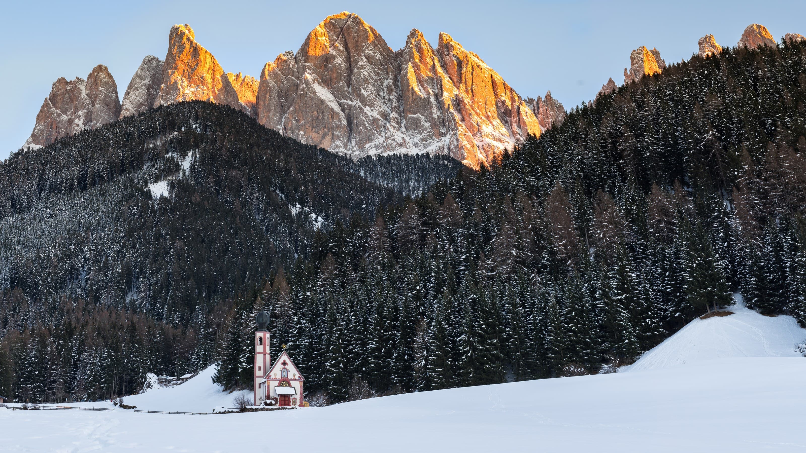 Kirche vor verschneiten Berggipfeln