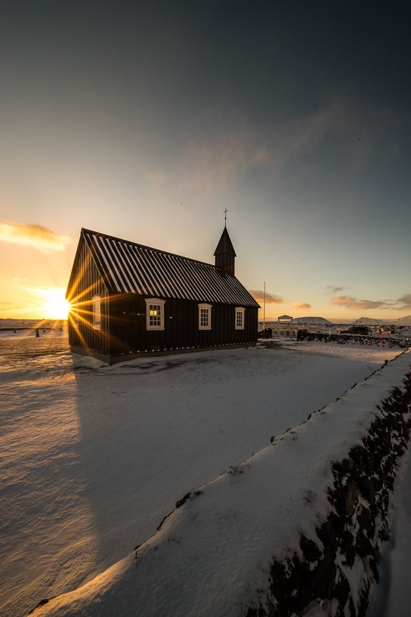 Schwarze Holzkirche an der Küste im Morgenlicht